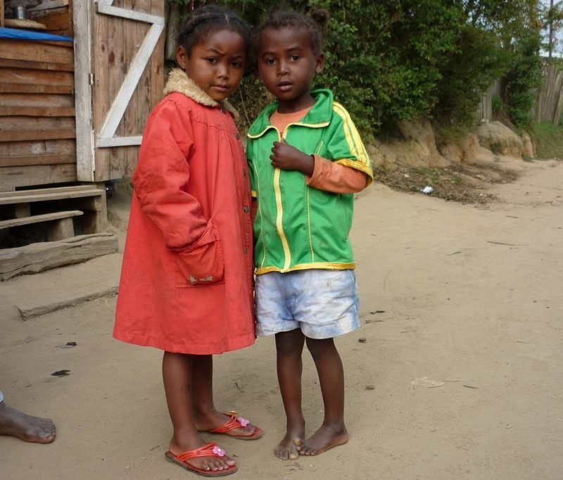 Deux jeunes enfants debout au bord d'un chemin de terre