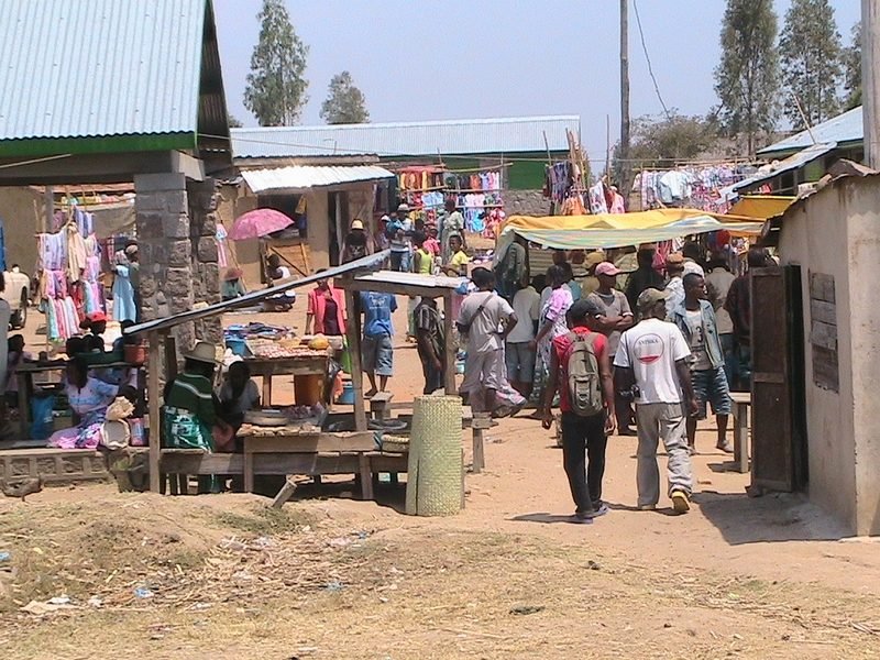 Rue de marché animée bordée d'étals et de linge suspendu